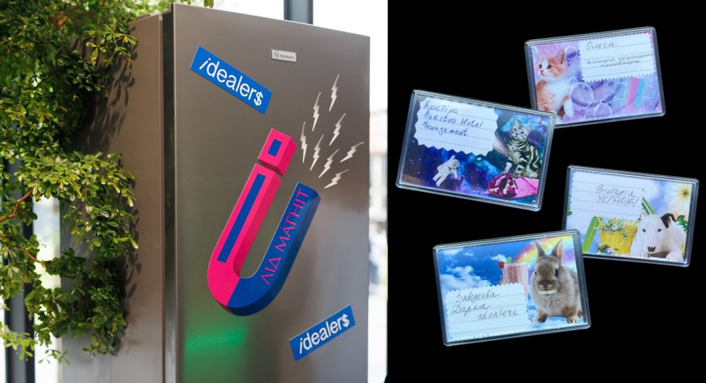 Фотографія магніта у формі букви 'М' із логотипом 'idealers' на холодильнику, оточеному зеленими рослинами.