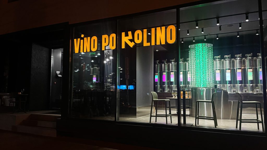 Фасад винного простору VINO PO KOLINO в Києві, з яскравим логотипом та вітриною, що демонструє сучасний інтер'єр та наливаторію.