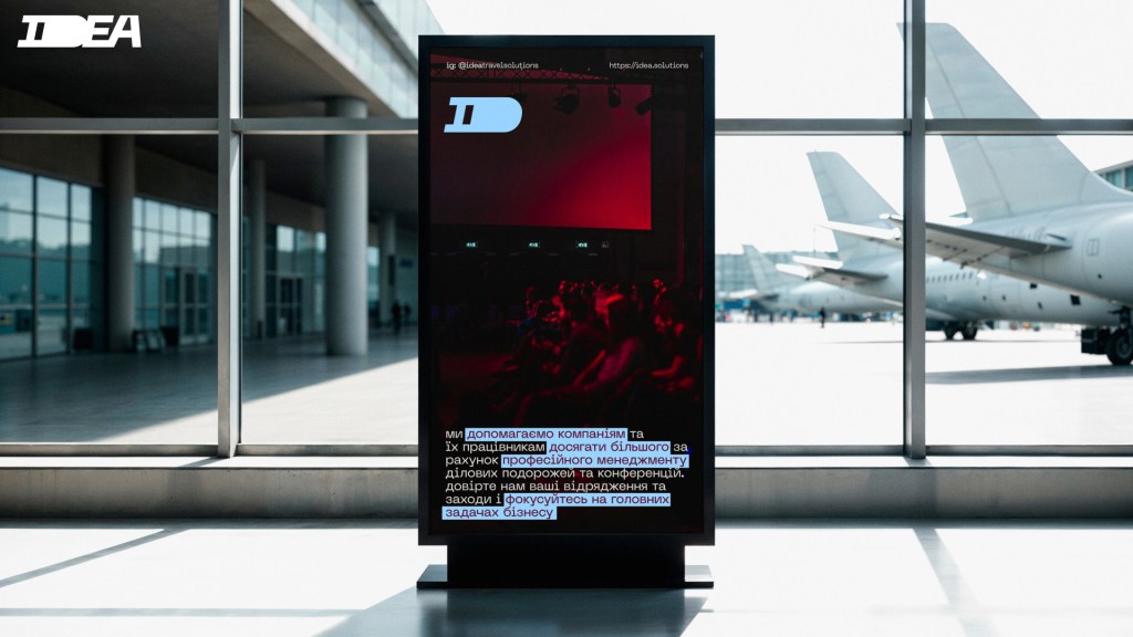 Сучасний цифровий екран з логотипом IDEA у аеропорту, що відображає інформацію про послуги компанії, на фоні літаків.